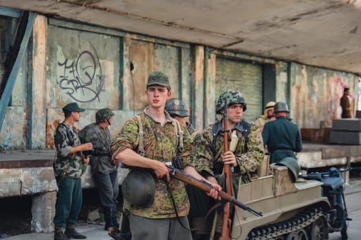 Hel, Poland - August 2022 Military troops marching during 3 May Polish Constitution Day ceremonial patriotic parade. Polish armed forces tanker military parade. Old guns and cars. Feast of Polish Armed Forces Day, American soldiers with US flag on parade Nato Vehicles Military Equipment