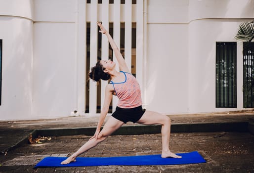 Young woman doing reverse warrior yoga outdoors. Girl doing yoga viparita virabhadrasana Attractive girl practicing reverse warrior yoga outdoors