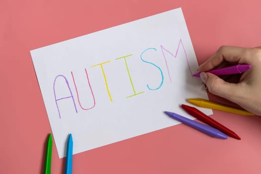 Text word autism on paper sheet written by colorful letter, on blue background