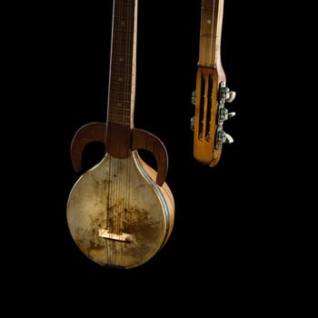 An ancient Asian stringed musical instrument on a black background