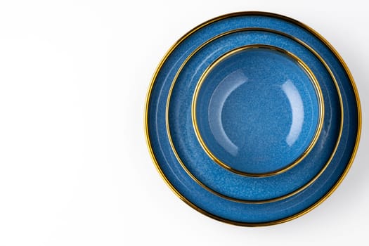 A set of blue ceramic plates on a white background. Top view