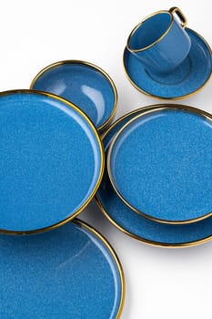 A set of blue ceramic plates and cup on a white background