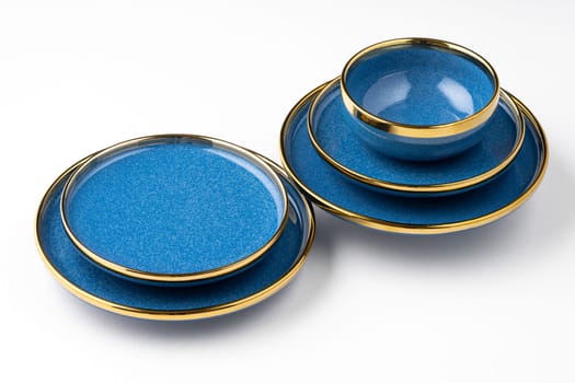 A set of blue ceramic plates and cup on a white background