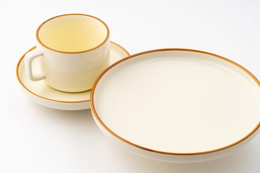 A set of white and brown ceramic plate and cup on a white background