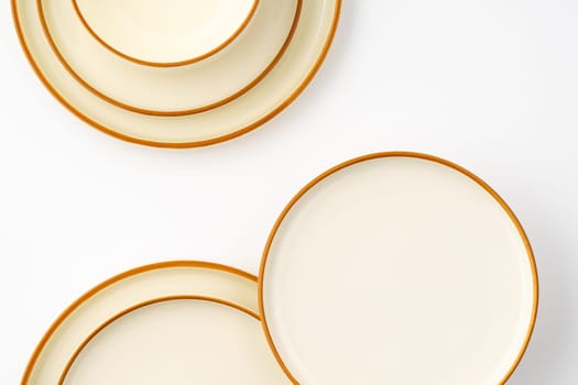 A set of white and brown ceramic plate and bowl on a white background. Top view