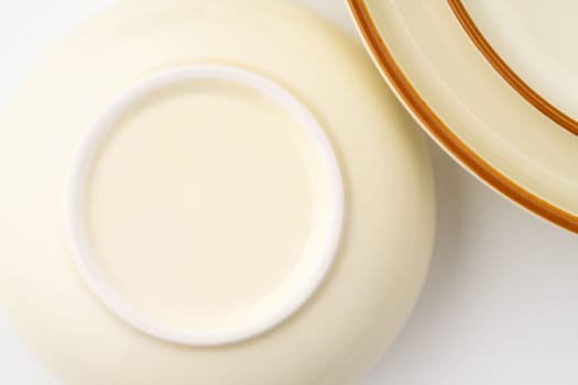 A set of white and brown ceramic plate and bowl on a white background. Close-up