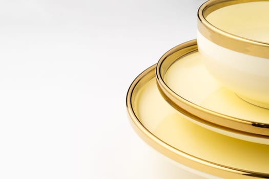 A closeup shot of golden luxury ceramic kitchen utensils on a white background