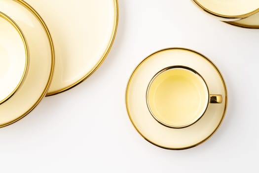 A set of golden luxury ceramic kitchen utensils on a white background