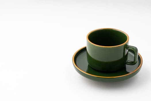 A set of green ceramic plate and coffee mug on a white background