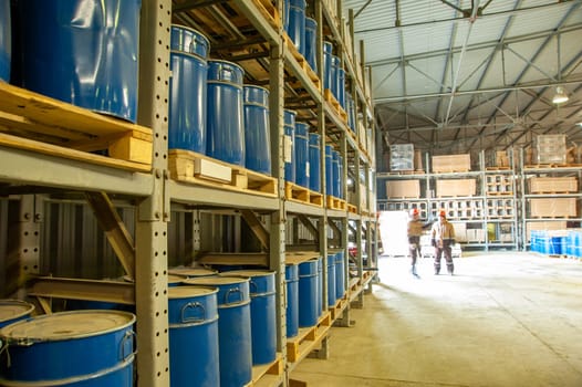 A warehouse with blue industrial metal barrels