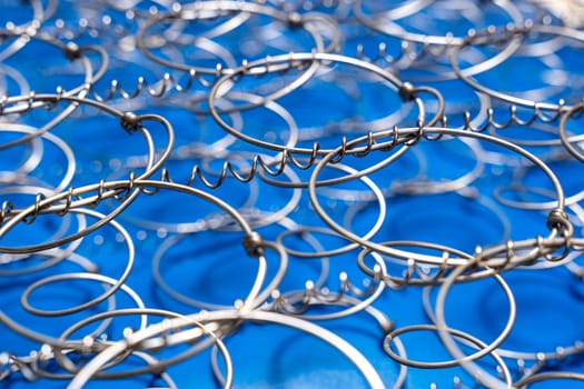 Abstract background The internal structure of a spring mattress. close-up of an old spring mattress on a blue background. Spring block. Sofa and bed. defocusing