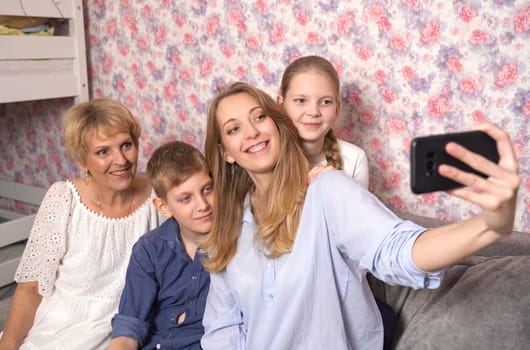 Happy woman takes selfie with kids and grandma.