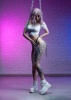 sexy girl in white underwear with metal chains in neon light