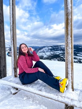 Shot of a skier woman sitting on the ski slope resting relaxing extreme recreation active lifestyle activity. Female skier on a slope in the mountains. Winter active sport Country cross skier in Alps