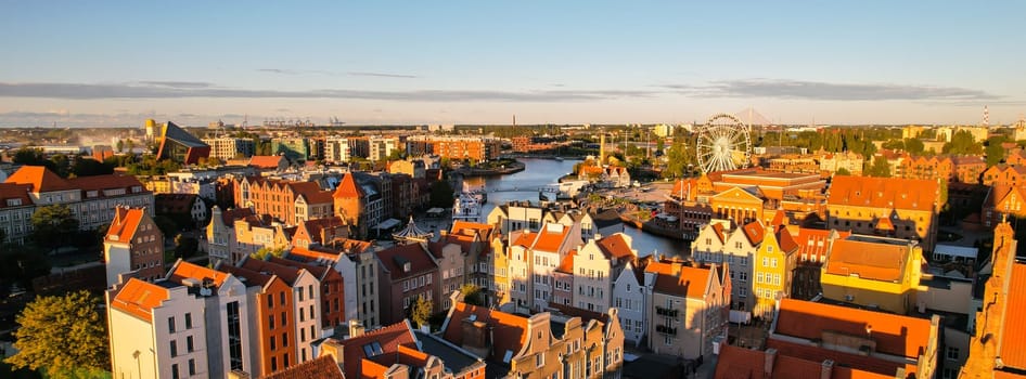 Beautiful architecture of old town in Gdansk, Poland at sunny day. Panorama banner size Aerial view from drone of the Main Town Hall and St. Mary Basilica. City Architecture from Above. Europe Tourist Attractions in Gdansk