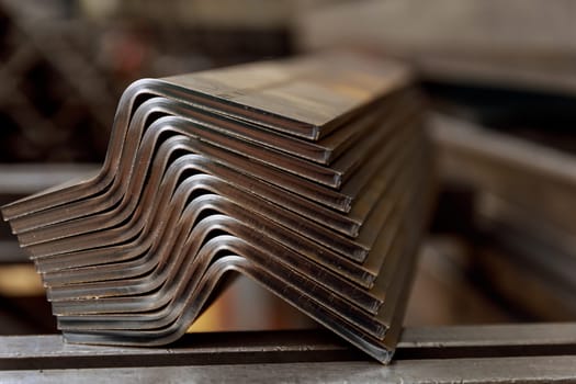 Products bent on a bending machine, close-up. Factory made metal parts.