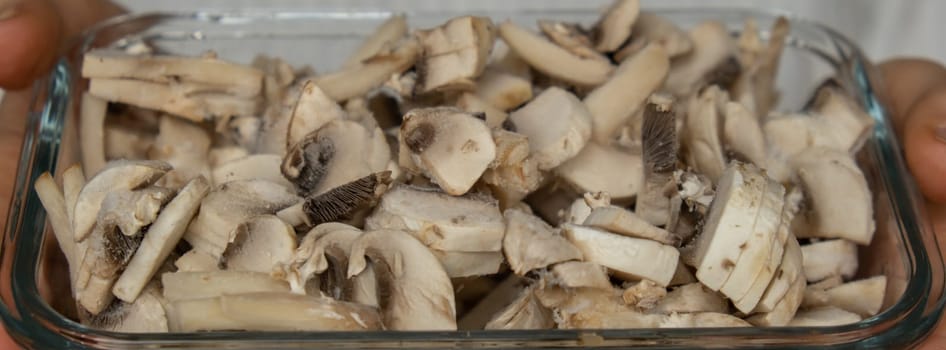 Unrecognizable woman showing into camera frozen food sliced mushrooms champignon homemade. Harvesting concept. Stocking up vegetables for winter storage Healthy food, Cooking ingredients