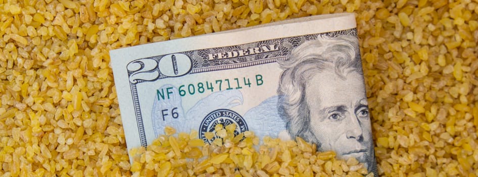 US Dollar bill paper money currency banknote in buckwheat porridge. The crisis in the market of grain crops, the rise in prices or production volumes of buckwheat Food and groceries shopping price increase, Rising food cost food crisis inflation concept.