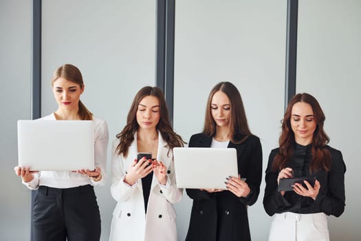 Group of adult women that in formal clothes is indoors in the office together.