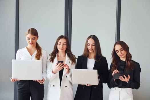 Group of adult women that in formal clothes is indoors in the office together.