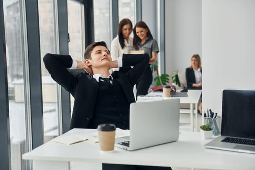 Man takes a break. Group of people in official formal clothes that is indoors in the office.