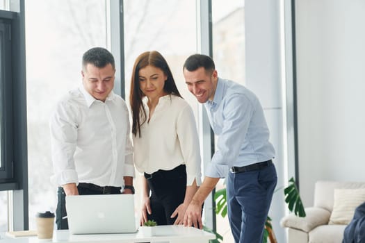 Group of people in official formal clothes that is indoors in the office.