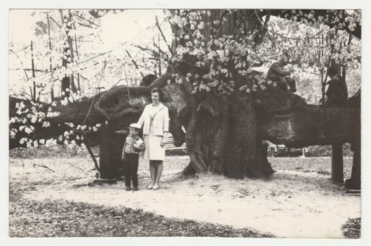 THE CZECHOSLOVAK SOCIALIST REPUBLIC - CIRCA 1970s: Vintage photo shows mother and son pose outdoors. Retro black and white photography. Circa 1970s.