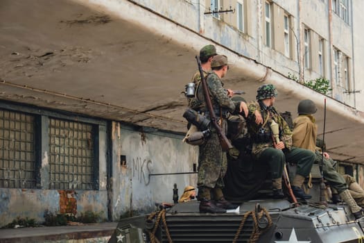 Hel, Poland - August 2022 Military troops marching during 3 May Polish Constitution Day ceremonial patriotic parade. Polish armed forces tanker military parade. Old guns and cars. Feast of Polish Armed Forces Day, American soldiers with US flag on parade Nato Vehicles Military Equipment