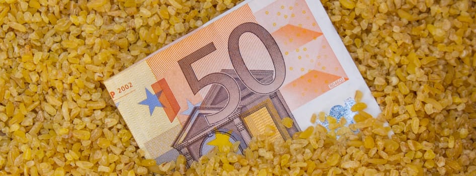 Euro bill paper money currency banknote in buckwheat porridge. The crisis in the market of grain crops, the rise in prices or production volumes of buckwheat Food and groceries shopping price increase, Rising food cost food crisis inflation concept.