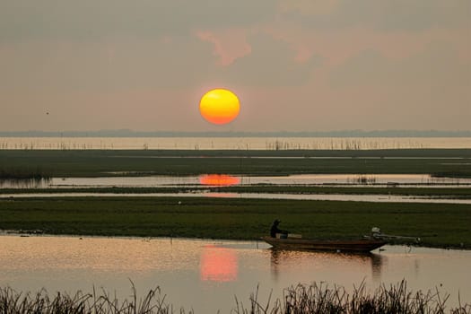 The large sunrise is orange. Sunrise over the sea and mangrove forest