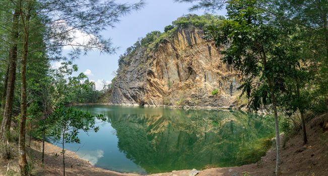 Emerald green pond
Caused by digging limestone mines Blue sky and white clouds , Tons of wood covered