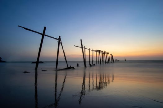 Sunset and reflections from the sea, decaying wooden bridges, Khao Pi Lai Phang Nga beach, Thailand