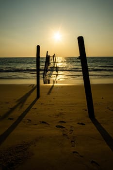 Sunset and reflections from the sea, decaying wooden bridges, Khao Pi Lai Phang Nga beach, Thailand