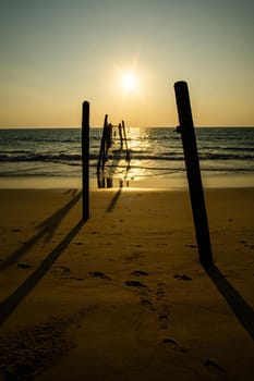 Sunset and reflections from the sea, decaying wooden bridges, Khao Pi Lai Phang Nga beach, Thailand