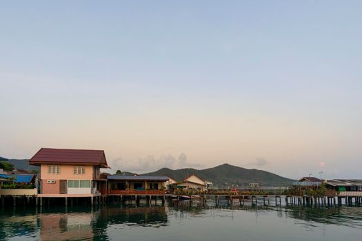 Fisherman's house and seaside house in Sattahip, reflecting with the water surface. Bright sky