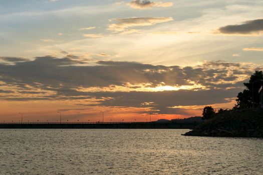 Sunset at the dam collecting water. Orange evening sky