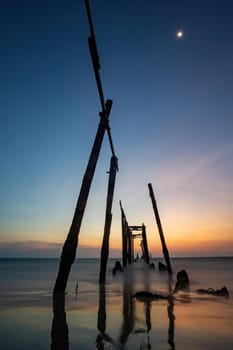 Sunset and reflections from the sea, decaying wooden bridges, Khao Pi Lai Phang Nga beach, Thailand