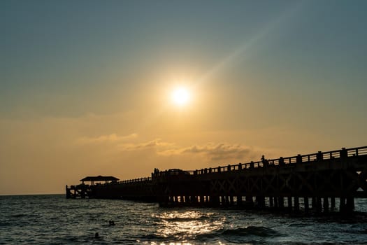 Bridge pier silhouette. The sun is falling in the Andaman Sea. Natai Beach in Phang Nga, Thailand