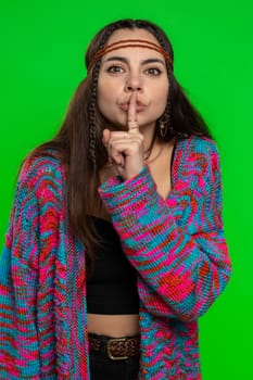 Shh be quiet please. Young woman presses index finger to lips makes silence gesture sign do not tells secret, stop gossip. Pretty hippie girl isolated alone on chroma key background, green screen