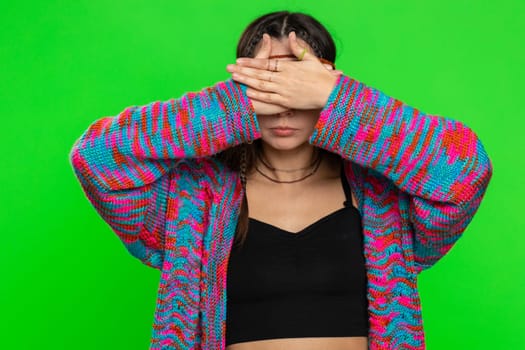 Dont want to look at this, awful. Afraid woman closing eyes with hand showing stop gesture, confused shy scared to watch. Young girl isolated on chroma key background, green screen. People lifestyles