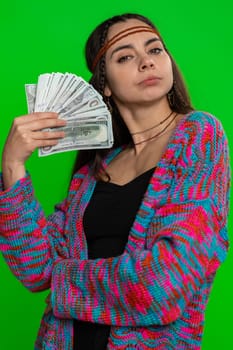 Rich pleased boss young woman waving money dollar cash banknotes bills like a fan, success business career, lottery winner, big income, wealth. Hippie girl isolated on green chroma key background