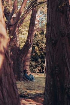 Attractive young woman reading book while sitting on grass in green public park. Springtime outdoors. Greenery unity with nature. Spend free time on open air. Education concept