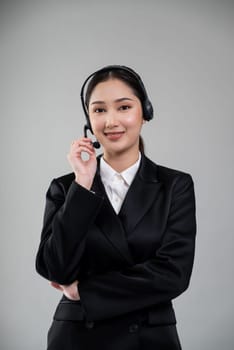 Attractive asian female call center operator with happy smile face advertises job opportunity on empty space, wearing a formal suit and headset on customizable isolated background. Enthusiastic