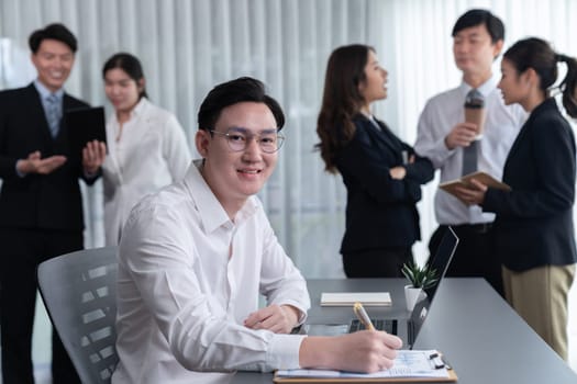 Portrait of focus young successful confident male manager, executive wearing business wear in harmony office arm crossed with blurred meeting background of colleagues, office worker.