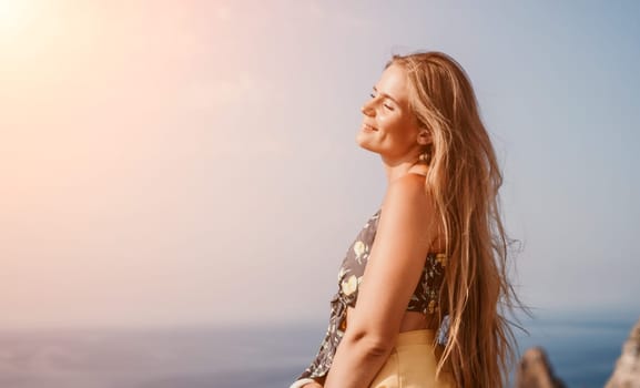 Woman travel sea. Happy tourist taking picture outdoors for memories. Woman traveler looks at the edge of the cliff on the sea bay of mountains, sharing travel adventure journey.