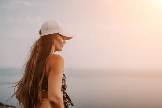 Woman travel sea. Happy tourist taking picture outdoors for memories. Woman traveler looks at the edge of the cliff on the sea bay of mountains, sharing travel adventure journey.