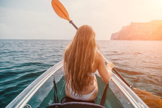 Woman in kayak back view. Happy young woman with long hair floating in transparent kayak on the crystal clear sea. Summer holiday vacation and cheerful female people having fun on the boat.