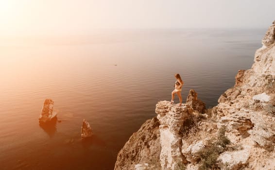 Woman travel sea. Happy tourist taking picture outdoors for memories. Woman traveler looks at the edge of the cliff on the sea bay of mountains, sharing travel adventure journey.