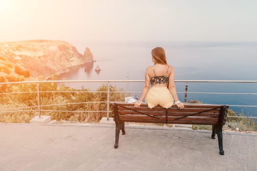 Woman travel sea. Happy tourist taking picture outdoors for memories. Woman traveler looks at the edge of the cliff on the sea bay of mountains, sharing travel adventure journey.