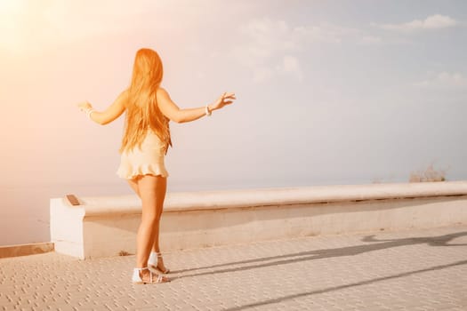 silhouette of a happy woman who dances, spins and raises her hands to the sky. A woman is enjoying a beautiful summer day.